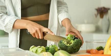 Two Eleven Health: Person Cutting Vegetables